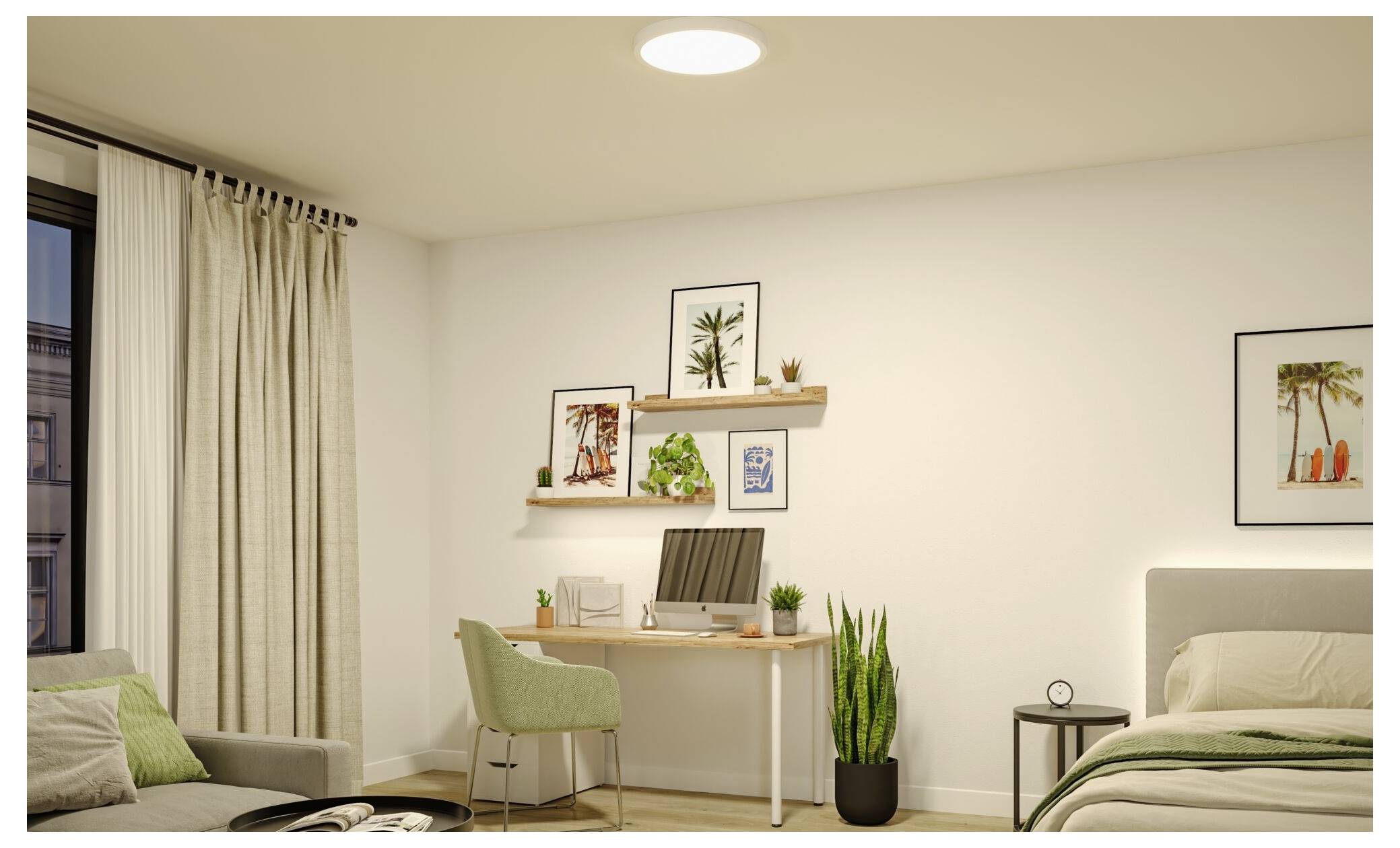 Ein ordentliches Schlafzimmer mit einem kleinen Arbeitsbereich: Schreibtisch, grüner Stuhl, Topfpflanze, Bett, Wandkunst und Vorhänge am Fenster.