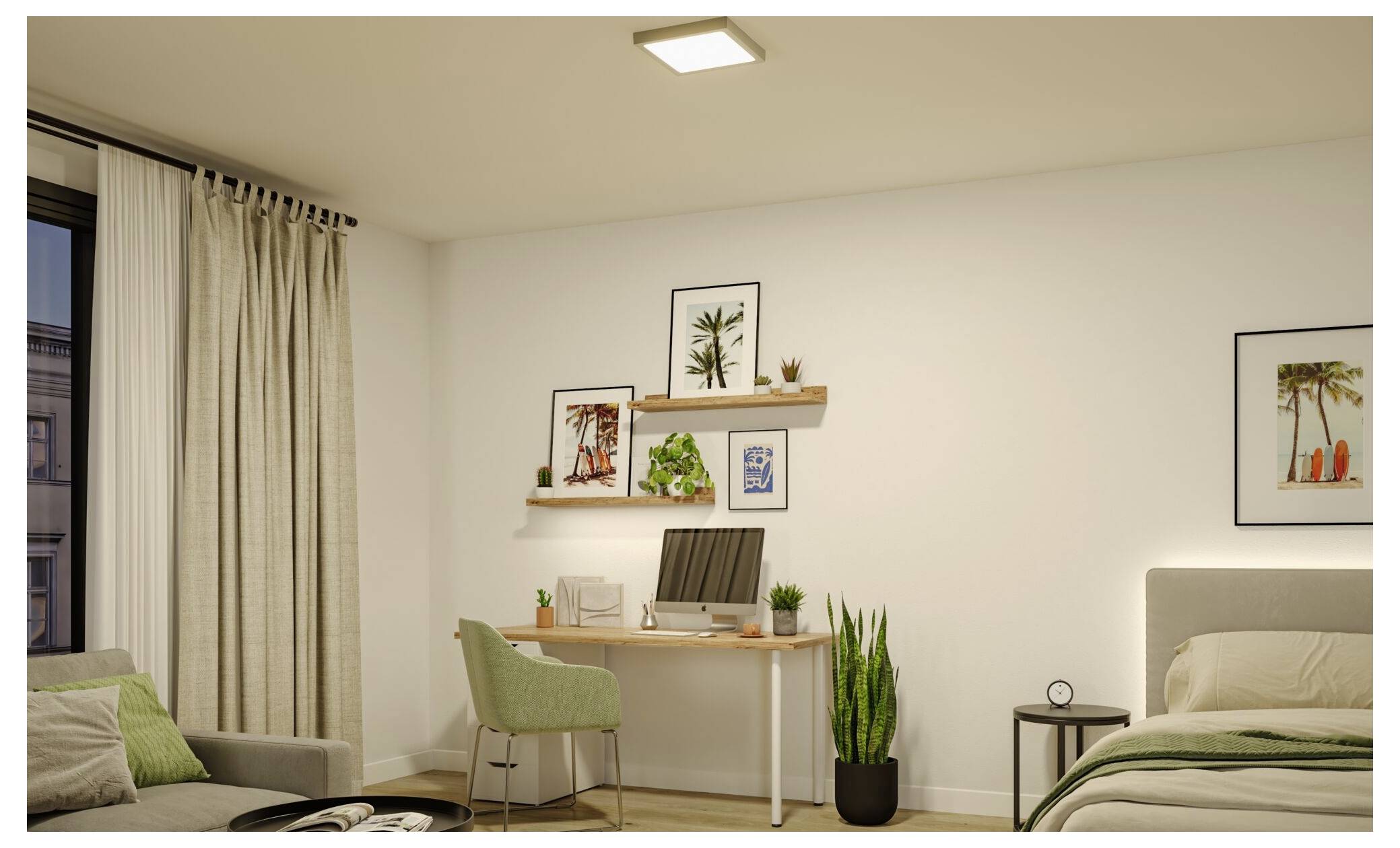 Helles Schlafzimmer mit einem Schreibtisch und grünem Stuhl, Wandregalen und gerahmter Kunst, Topfpflanze, Bett auf der rechten Seite und Fenster mit Vorhängen auf der linken Seite.