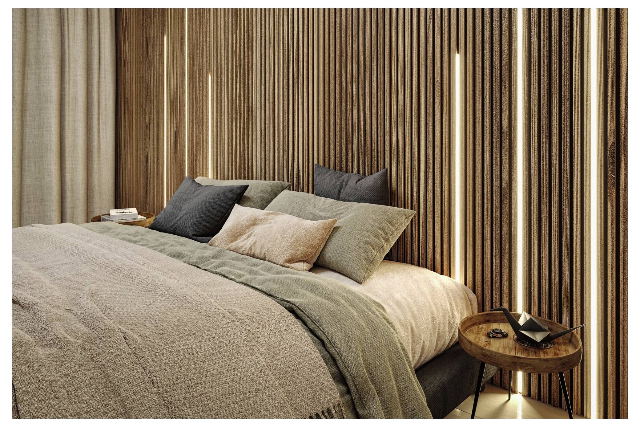 Modernes Schlafzimmer mit ordentlich gemachtem Bett, mehrschichtige neutrale Bettwäsche, Kissen und ein kleiner runder Nachttisch neben vertikal verlaufenden Holzlatttenwänden.