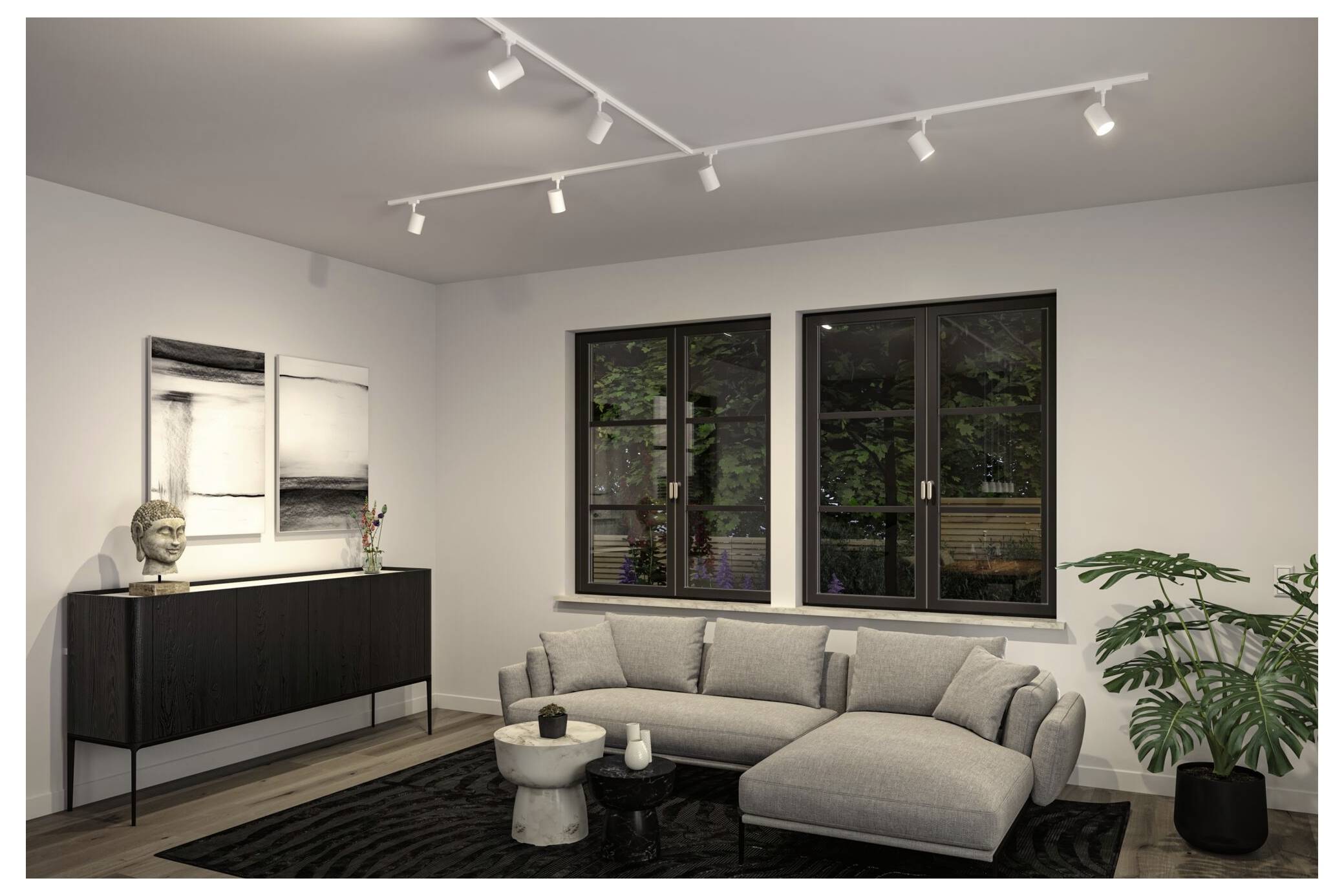 Modernes Wohnzimmer mit grauem Ecksofa, schwarzem Sideboard, Wandkunst, Schienensystem-Beleuchtung und großen Fenstern mit Blick auf Grünflächen.