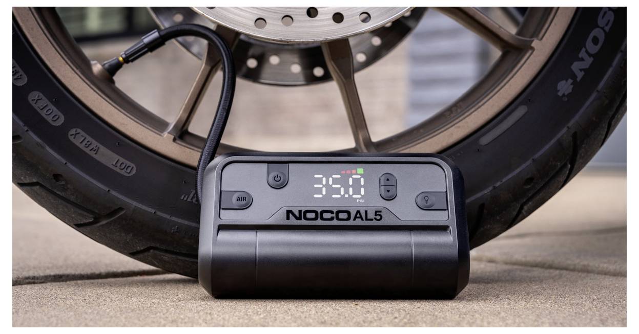 NOCO AL5 Reifenluftpumpe vor einem Autorad, zeigt eine digitale Druckanzeige von 35,0 PSI.
