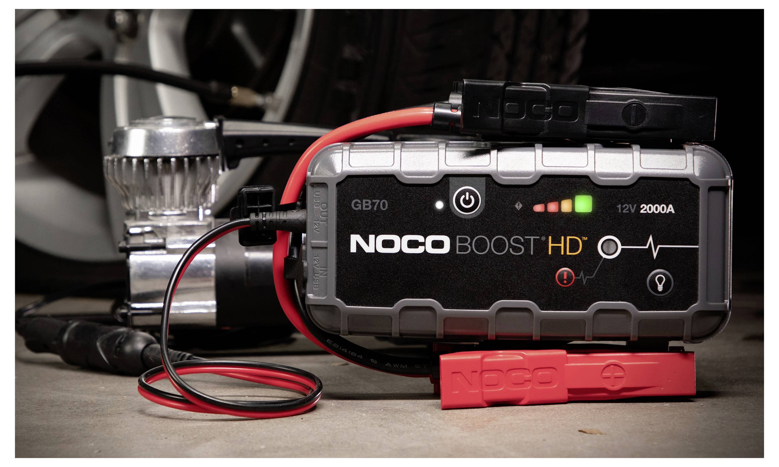 NOCO Boost HD tragbarer Starthilfegerät für Autos mit verbundenen Klemmen und Kabeln, zeigt Lade- und 12V 2000A-Indikatoren auf der Gerätenanzeige.