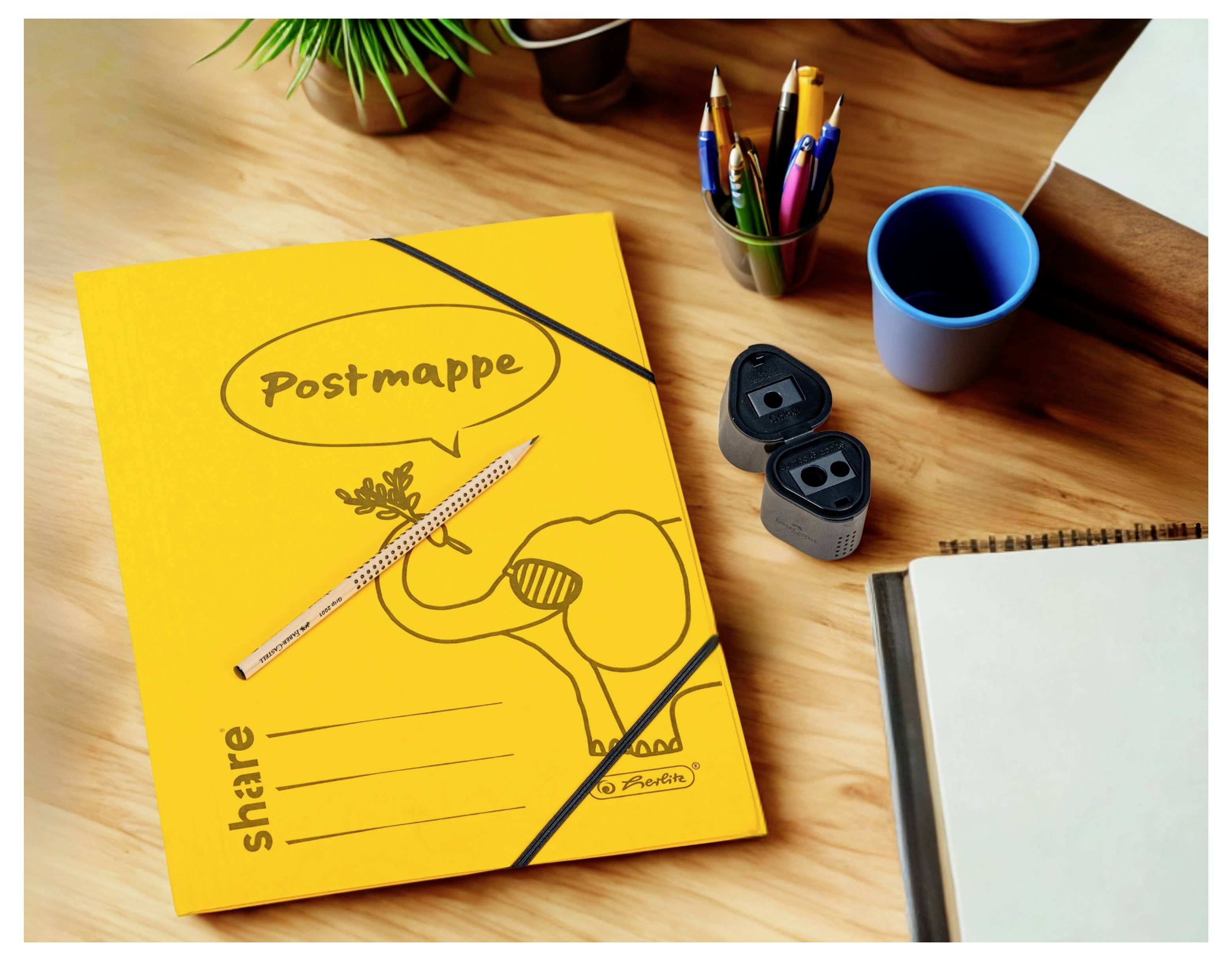 Gelber 'Postmappe'-Ordner auf einem Schreibtisch mit Stiften, Bechern und einem Notizbuch, was auf einen Schreib- oder Büroarbeitsplatz hindeutet.
