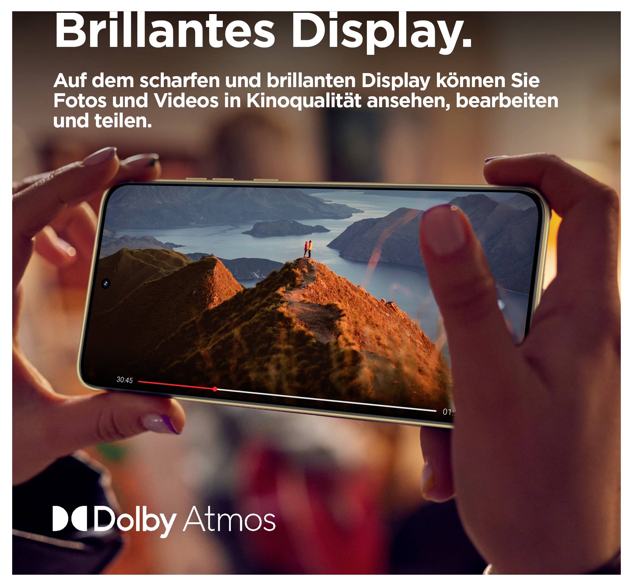 Smartphone wird mit beiden Händen gehalten und spielt ein Landschaftsvideo ab; deutscher Text besagt, dass das scharfe, brillante Display es dir ermöglicht, Fotos und Videos in Kinoqualität anzuschauen, zu bearbeiten und zu teilen. Dolby Atmos Logo.