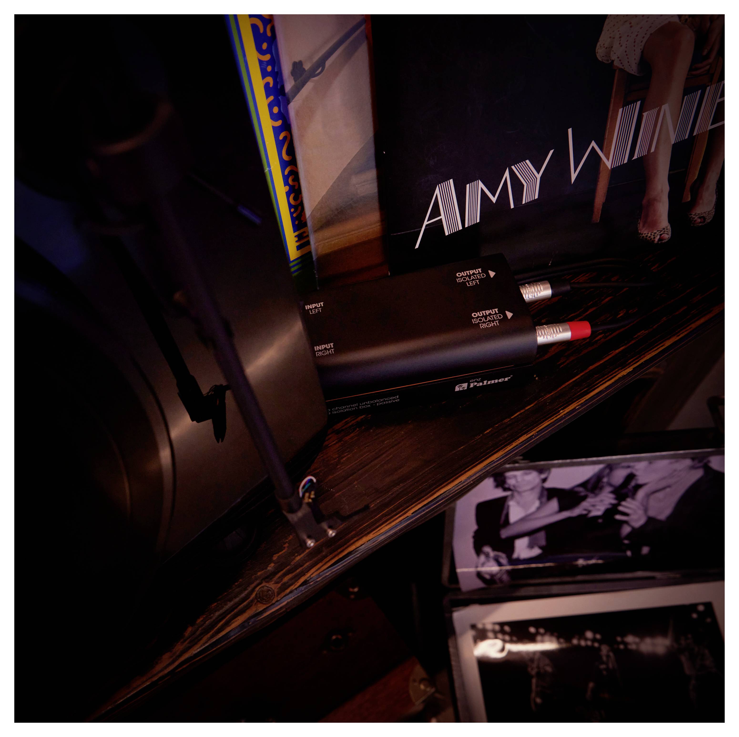 Nahaufnahme einer Amy-Winehouse-Schallplatten-Ausstellung mit einer Schallplattenhülle, Albumcover und schwarzroter Audioausrüstung auf einem Regal.