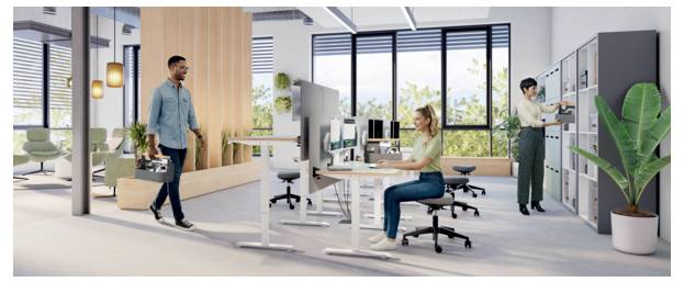 Modernes Großraumbüro mit einem Mann, der einen Aktenkoffer trägt und an einer sitzenden Frau an einem Schreibtisch vorbeigèht, mit Computern, Trennwänden und Lagerschränken.