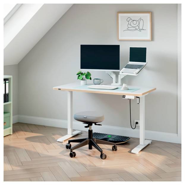 Kompaktes Home-Office-Setup mit Stehschreibtisch, Monitor, Laptop, Hocker, Tastatur, Pflanze, Tasse und gerahmter Wandkunst in einem sonnigen Raum.