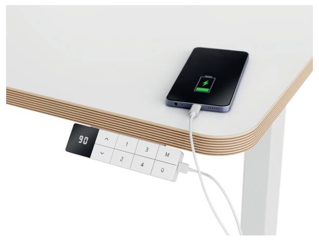 Ein Smartphone, das auf einem Schreibtisch neben einem kleinen Tisch-Kontrollfeld aufgeladen wird, auf dem „90