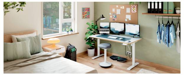 Ein ordentliches Schlafzimmer-Arbeitsbereich mit einem Schreibtisch, drei Monitoren, Hocker, Laptop-Tasche, Pflanze, Notizen an der Wand und hängenden Kleidern neben dem Bett.