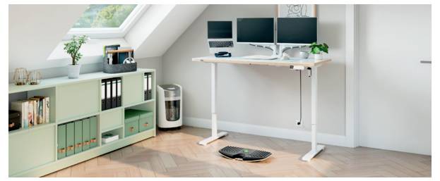 Minimales Homeoffice mit Stehschreibtisch, zwei Monitoren, Tastatur und Maus, plus Aktenschrank und Regale in einem hellen Dachzimmer.