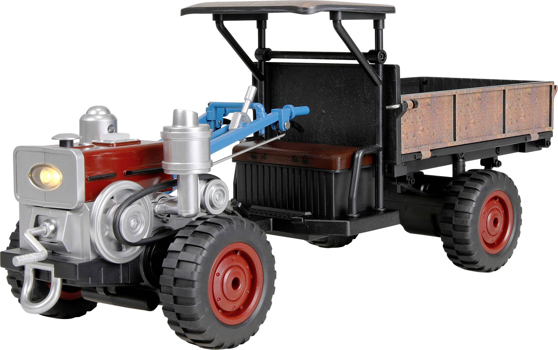 Ein Spielzeugtraktor mit Flachbettanhänger, in der Seitenansicht auf weißem Hintergrund dargestellt.