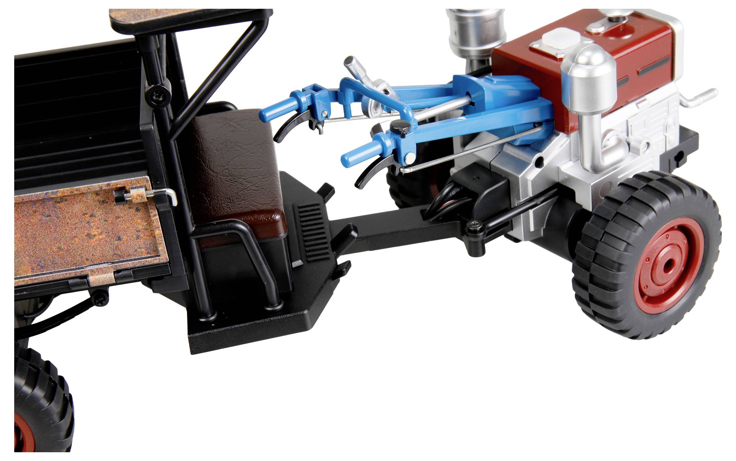 Ein Spielzeug-Zugmaschinen- oder Farmfahrzeugmodell mit einem roten Motorblock, einer schwarzen Kabine und einem blauen vorderen Kupplungsmechanismus auf weißem Hintergrund.