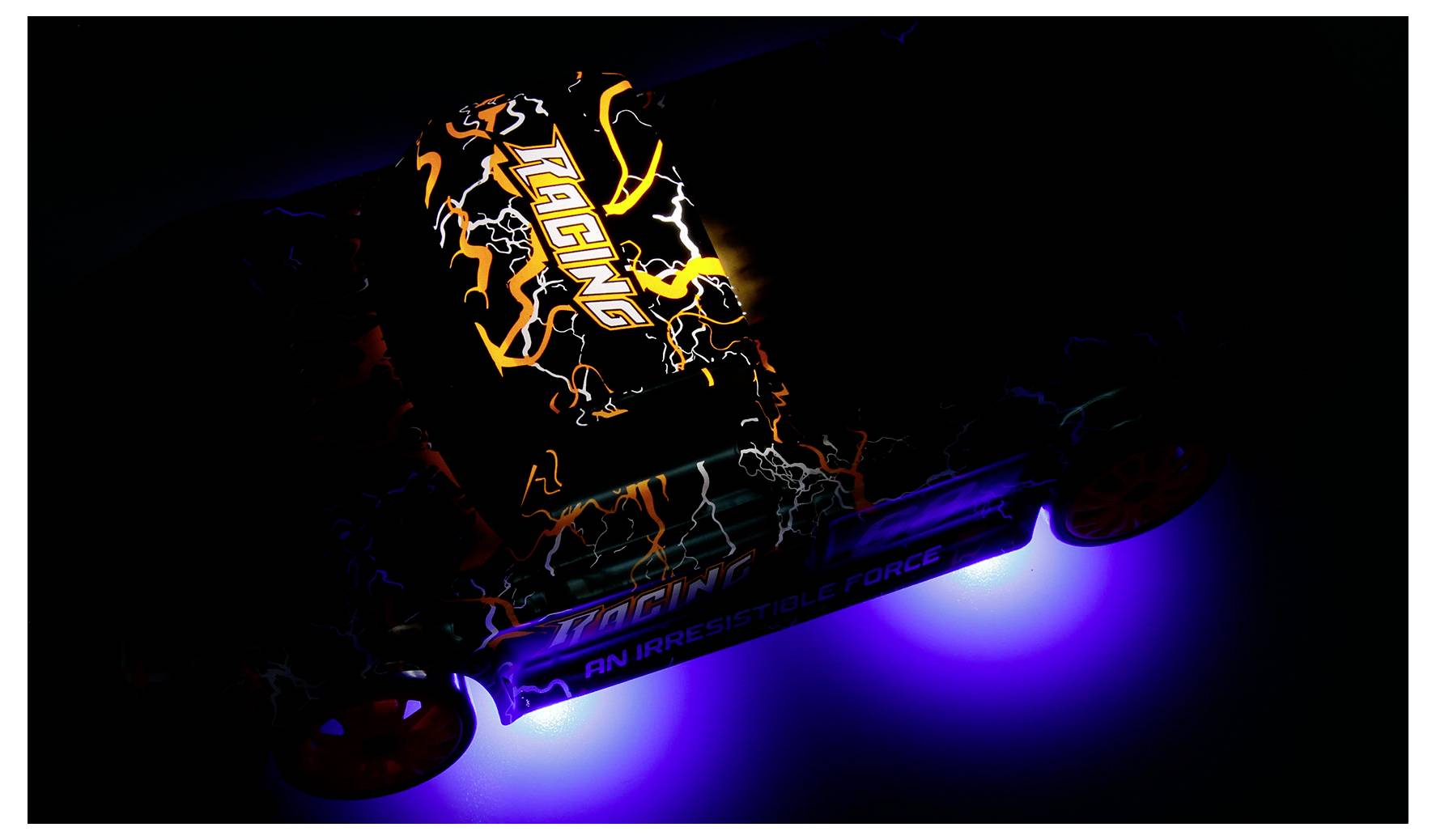 Ein schwarzes RC-Auto mit orangefarbigen Blitzgrafiken und leuchtenden blauen Unterbodenlichtern, vor einem dunklen Hintergrund betrachtet.