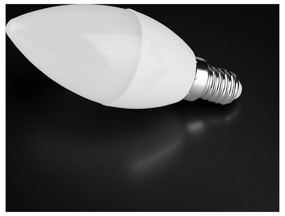 Eine weiße LED-Glühbirne, die auf ihrer Seite gegen einen dunklen Hintergrund liegt.