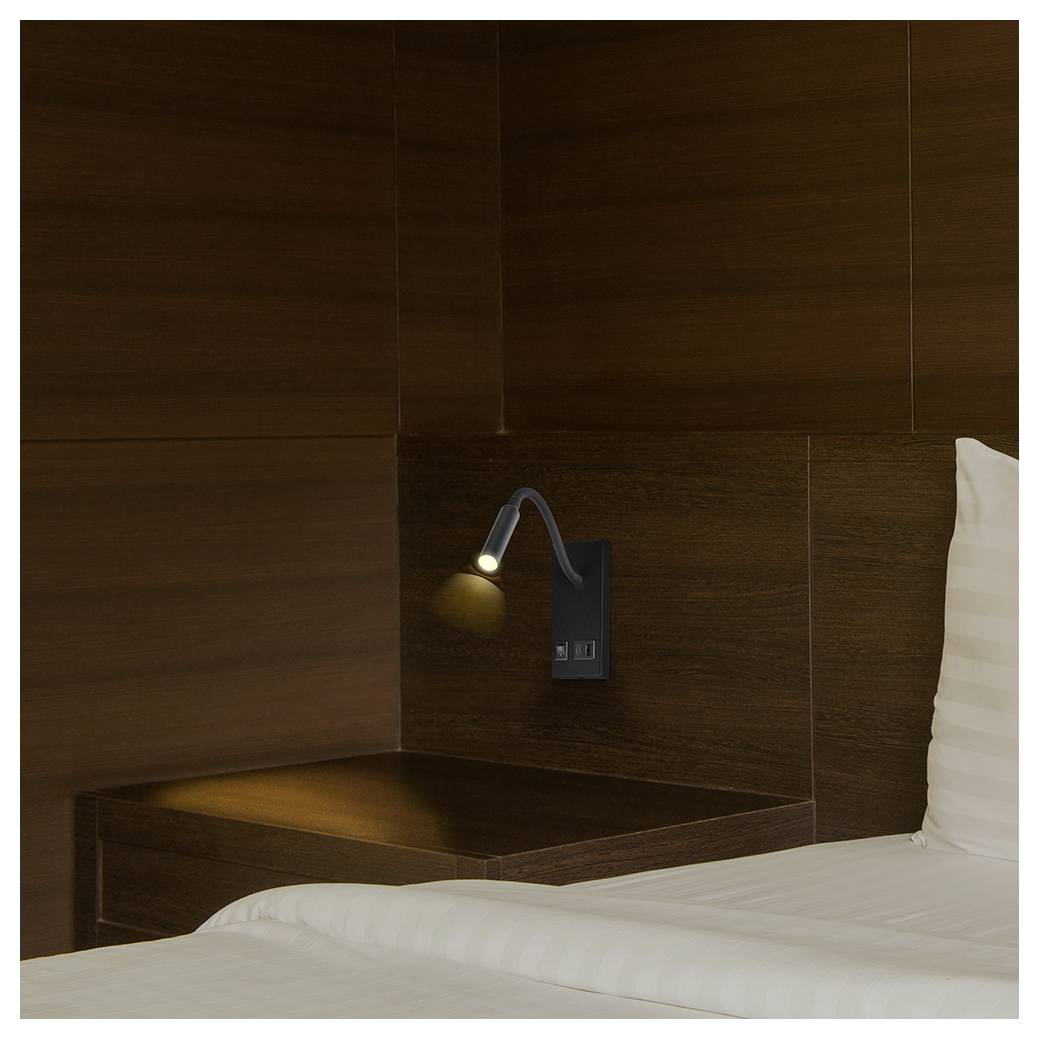 Minimale Hotelzimmerecke mit einer wandmontierten Leselampe über einem Nachttisch, neben einem weißen Bett und Kissen.