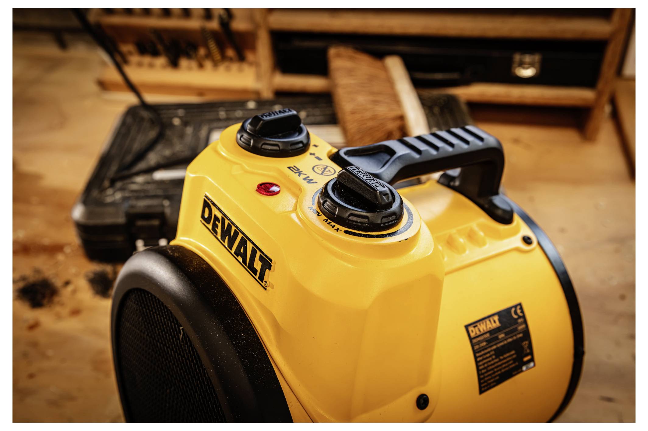 Gelber tragbarer elektrischer DEWALT-Raumheizer mit schwarzem Griff und Bedienreglern, gezeigt auf einem Werkstattboden.