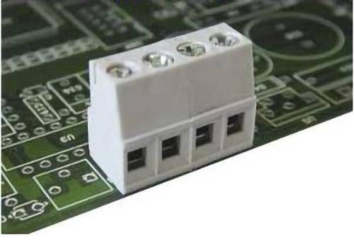 Nahaufnahme eines weißen dreipoligen Schraubklemmblocks, der auf einer grünen Leiterplatte montiert ist.