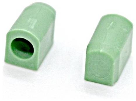 Zwei kleine grüne Kunststoff-Zylinder-Batteriestöpsel oder -Anschlüsse auf weißem Hintergrund, einer zeigt eine hohle Öffnung.