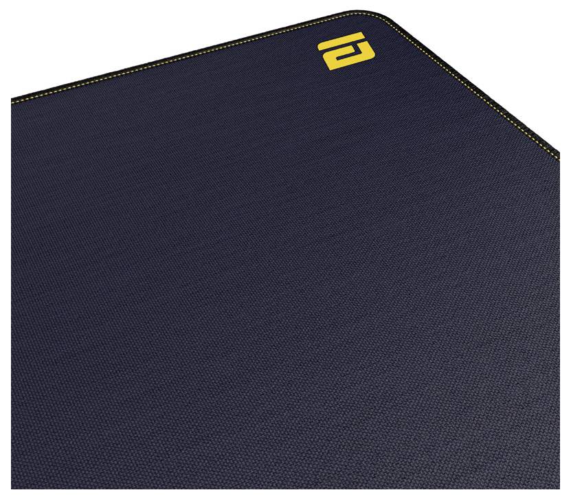 Schwarze strukturierte Matte oder Mousepad mit gelb gesäumter Kante und kleinem gelbem Logo in der oberen rechten Ecke.