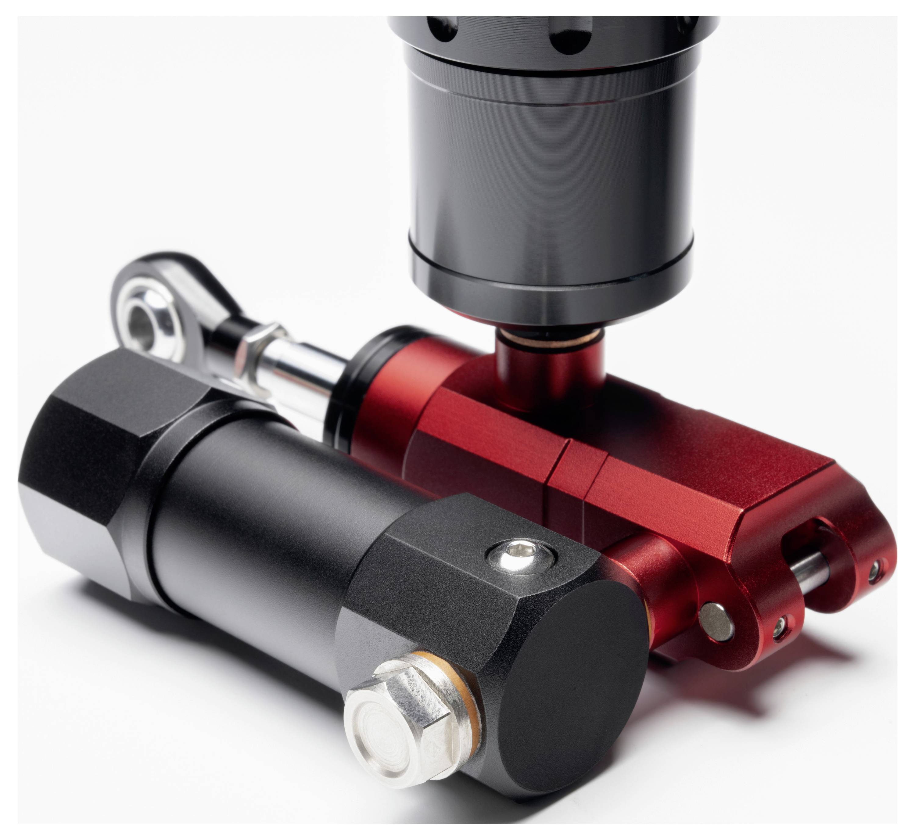 Zwei kompakte Metall-Hydraulikzylinder, einer schwarz und einer rot, in Großaufnahme auf weißem Hintergrund dargestellt.
