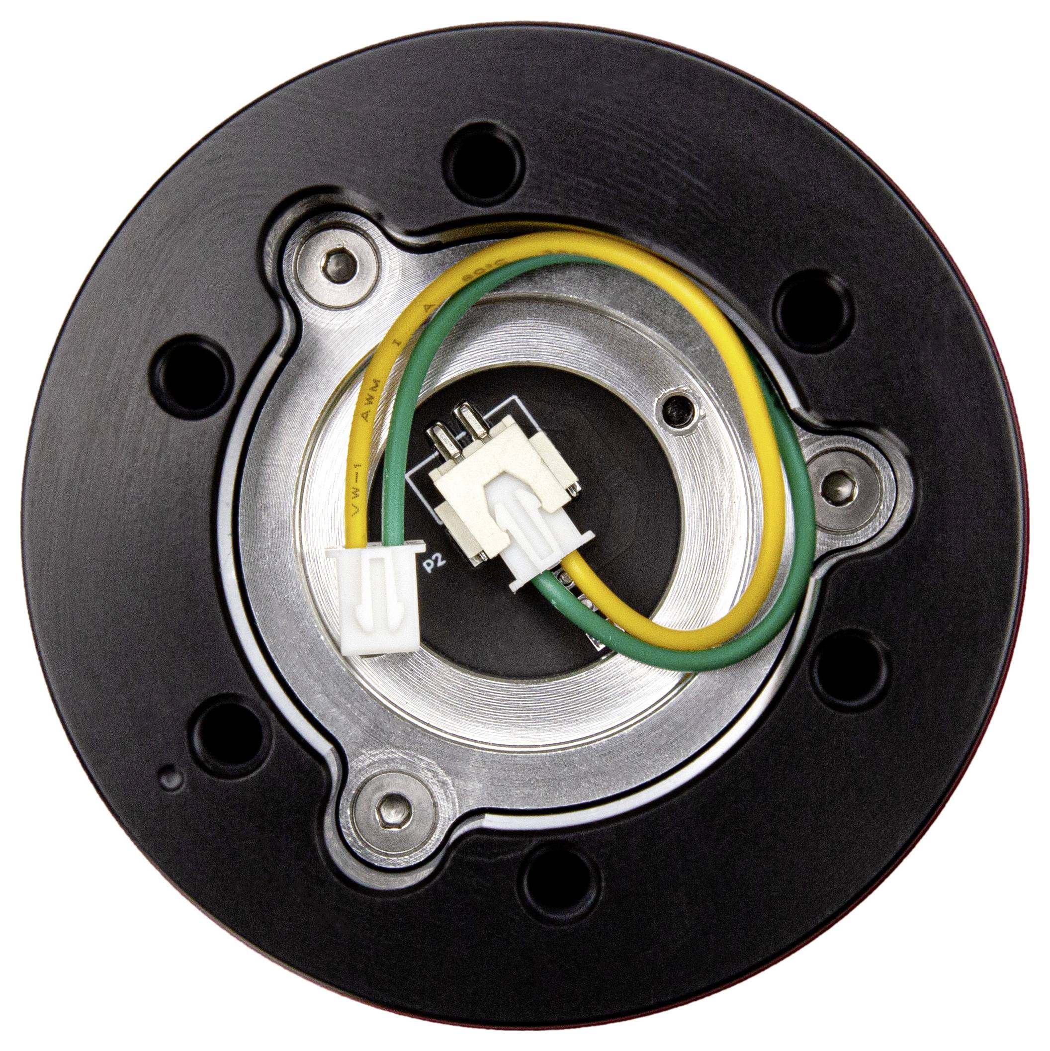 Nahaufnahme einer kreisförmigen elektronischen Komponente mit schwarzem Außengehäuse, metallischem Ring und grün-gelben Drähten, die mit weißen Steckern verbunden sind.