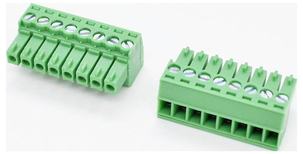 Zwei grüne elektrische Klemmenblock-Stecker auf weißem Hintergrund dargestellt, einer angewinkelt, um die Schraubklemmen und Drahtöffnungen zu zeigen.