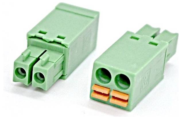 Zwei grüne Elektrostecker mit je zwei runden Anschlüssen, einer zeigt orange innere Kontakte, auf weißem Hintergrund.