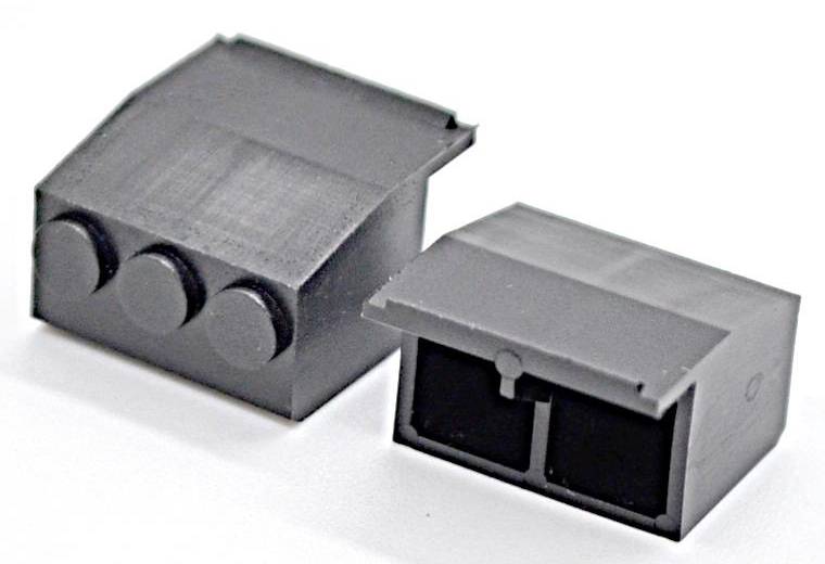 Zwei kleine graue rechteckige elektronische Gerätegehäuse, eines mit drei runden Frontschaltflächen und eines mit einem offenen vorderen Fach.