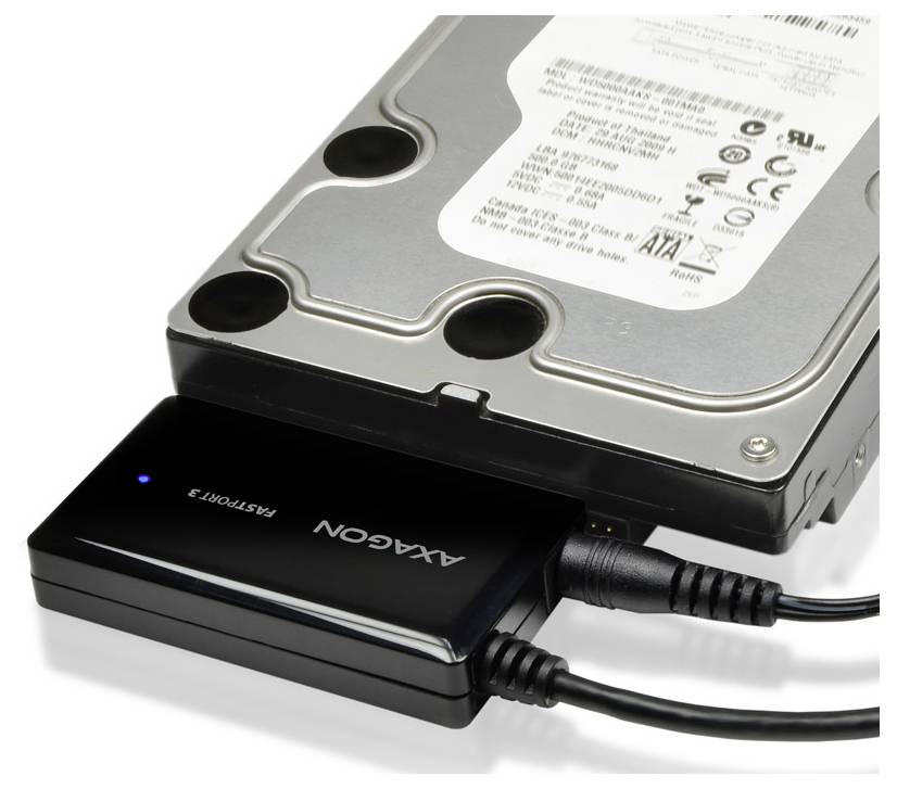 Externer Festplattenadapter, der mit einer Desktop-Festplatte verbunden ist, wobei zwei USB-Kabel angeschlossen sind.