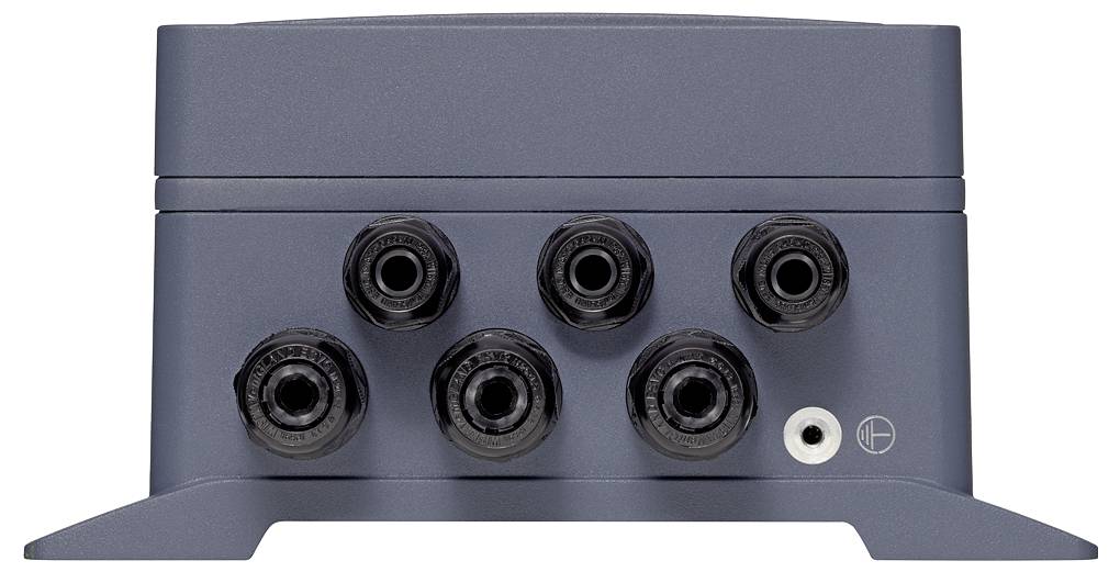 Vorderansicht eines grauen elektronischen Geräts mit sechs kreisförmigen schwarzen Eingangsbuchsen und einem kleinen weißen Anschluss auf der Frontplatte.