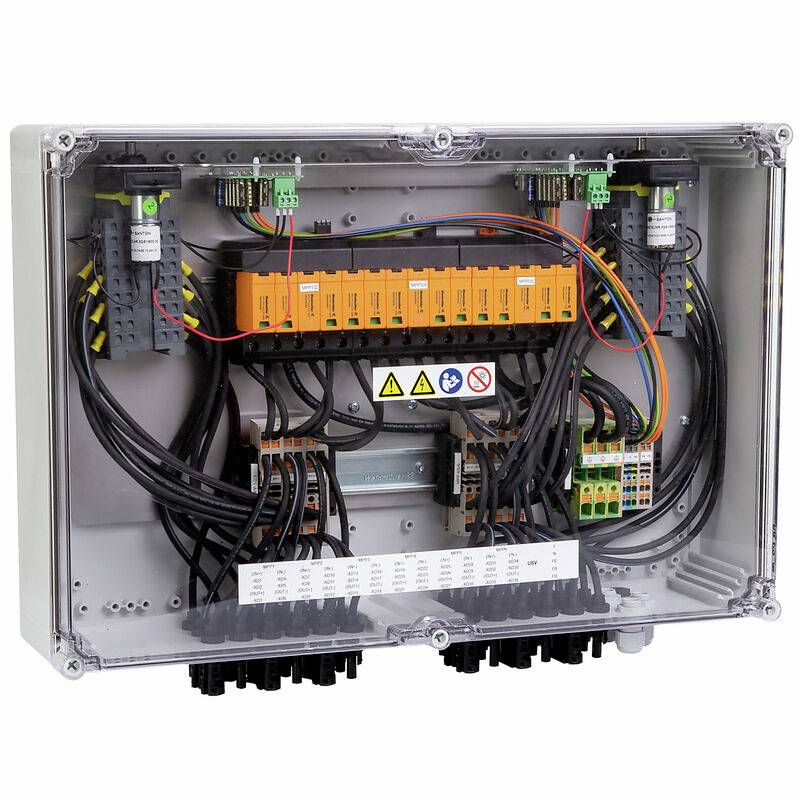 Offenes elektrisches Schaltpanel mit orangefarbenen Klemmenblöcken, Verdrahtung, Warnetiketten und Kabelverschraubungen in einem transparenten Schutzgehäuse.