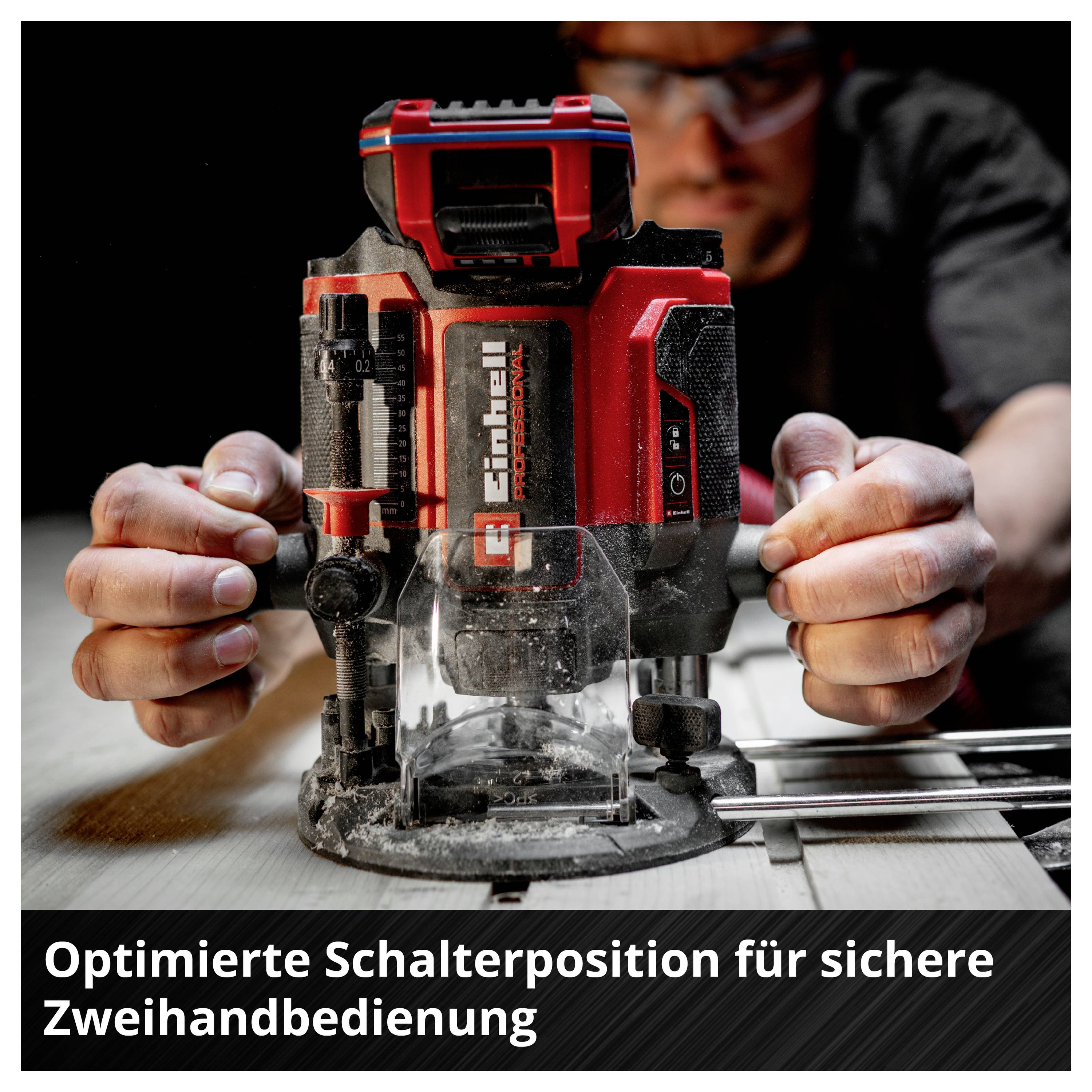 Mann hält eine rote Oberfräse mit beiden Händen; Bildtext: 'Optimierte Schalterposition für sichere Zweihandbedienung'.