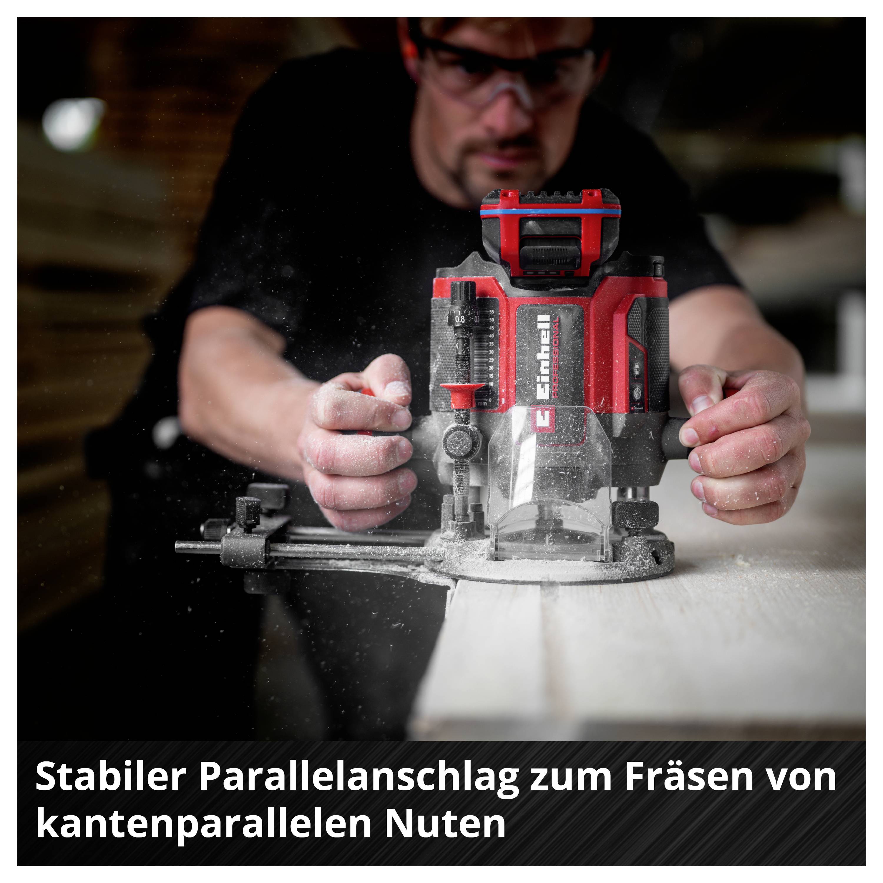 Person fräst mit einer roten Oberfräse eine Nut an einer Holzplatte; der Parallelanschlag sorgt für präzise, kantenparallele Führung.