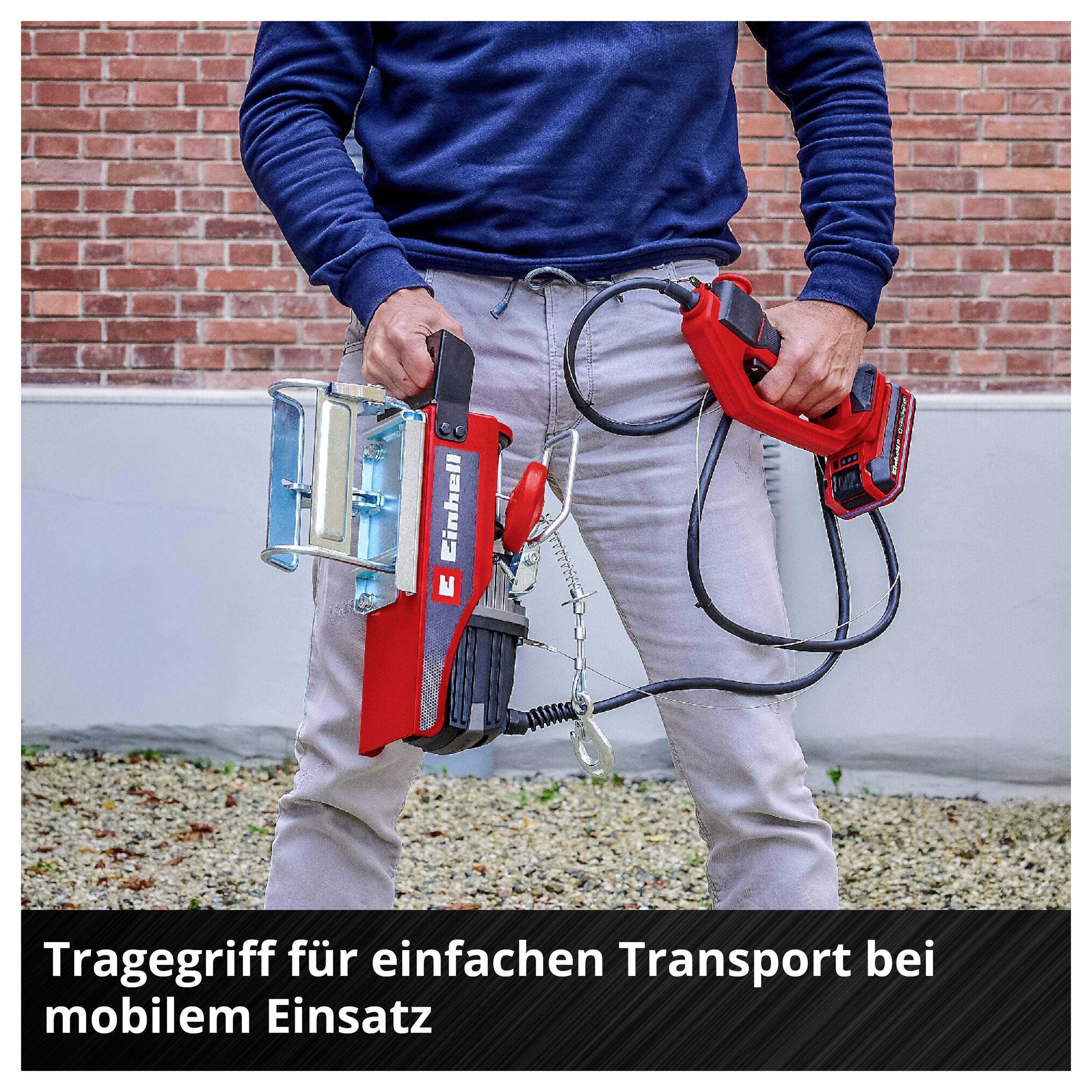 Person hält einen roten Tragegriff mit Gerät und Kabeln; Bildtext: 'Tragegriff für einfachen Transport bei mobilem Einsatz'