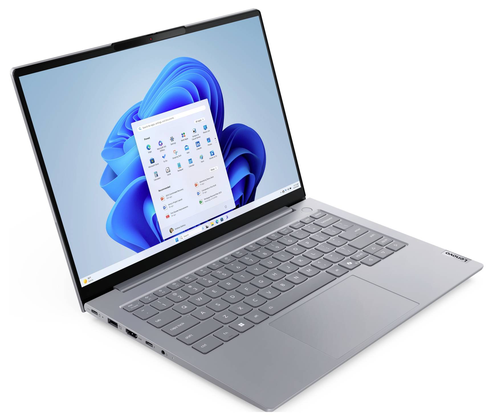 Silberner Lenovo-Laptop in einem Winkel geöffnet, auf dem Bildschirm sind der Windows 11-Desktop und das Startmenü zu sehen.