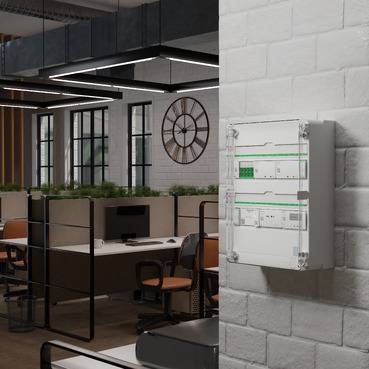 Bürointerior mit einem an der Wand montierten elektrischen Schaltschrank im Vordergrund, mit Blick auf moderne Bürokabinen und Schreibtische im Hintergrund.