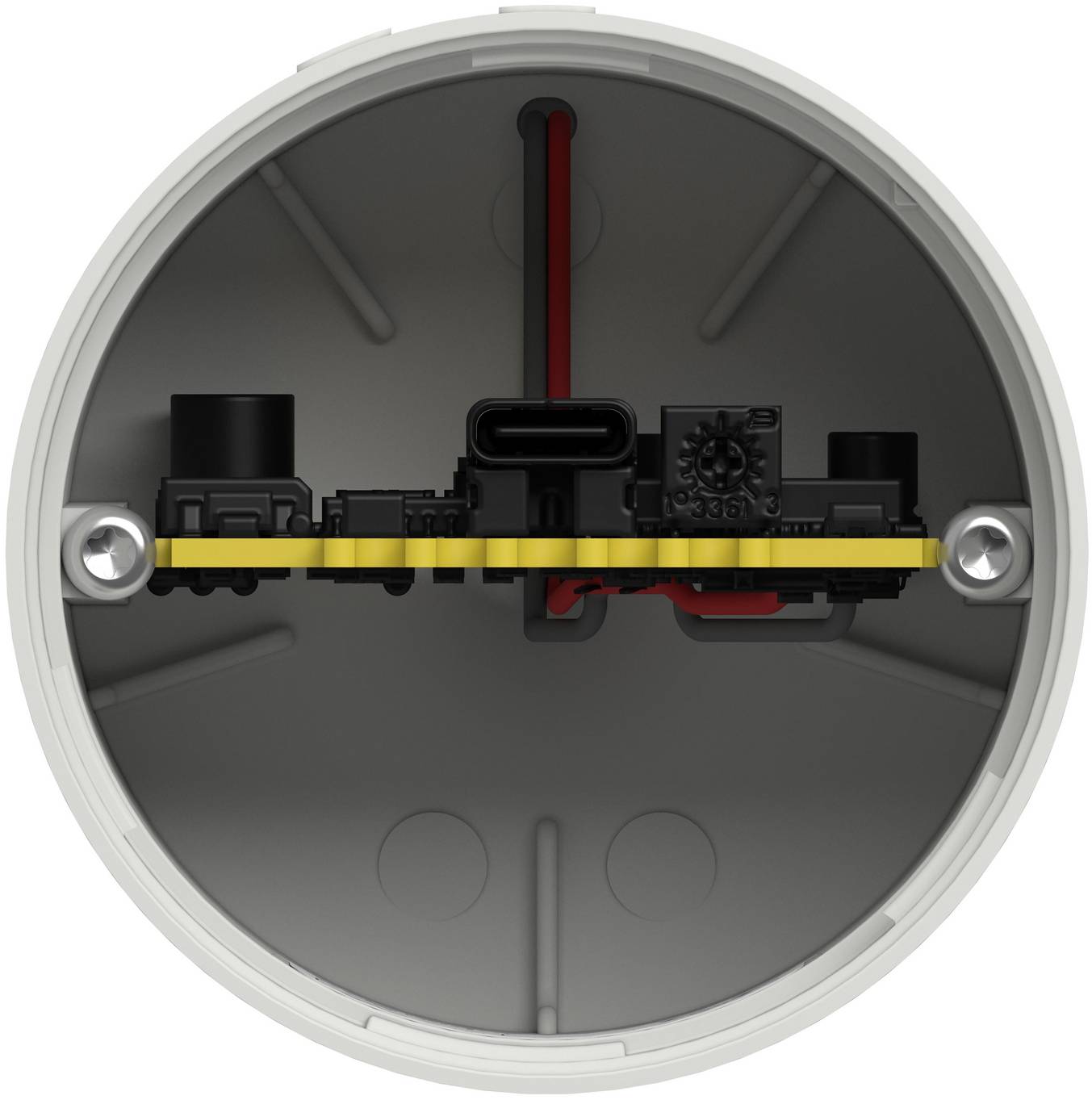 Innerhalb einer runden grauen elektrischen Verteilerdose ist eine schwarze Klemmenleiste mit einer gelben Erdungsschiene horizontal montiert, wobei rote Verdrahtung dahinter sichtbar ist.