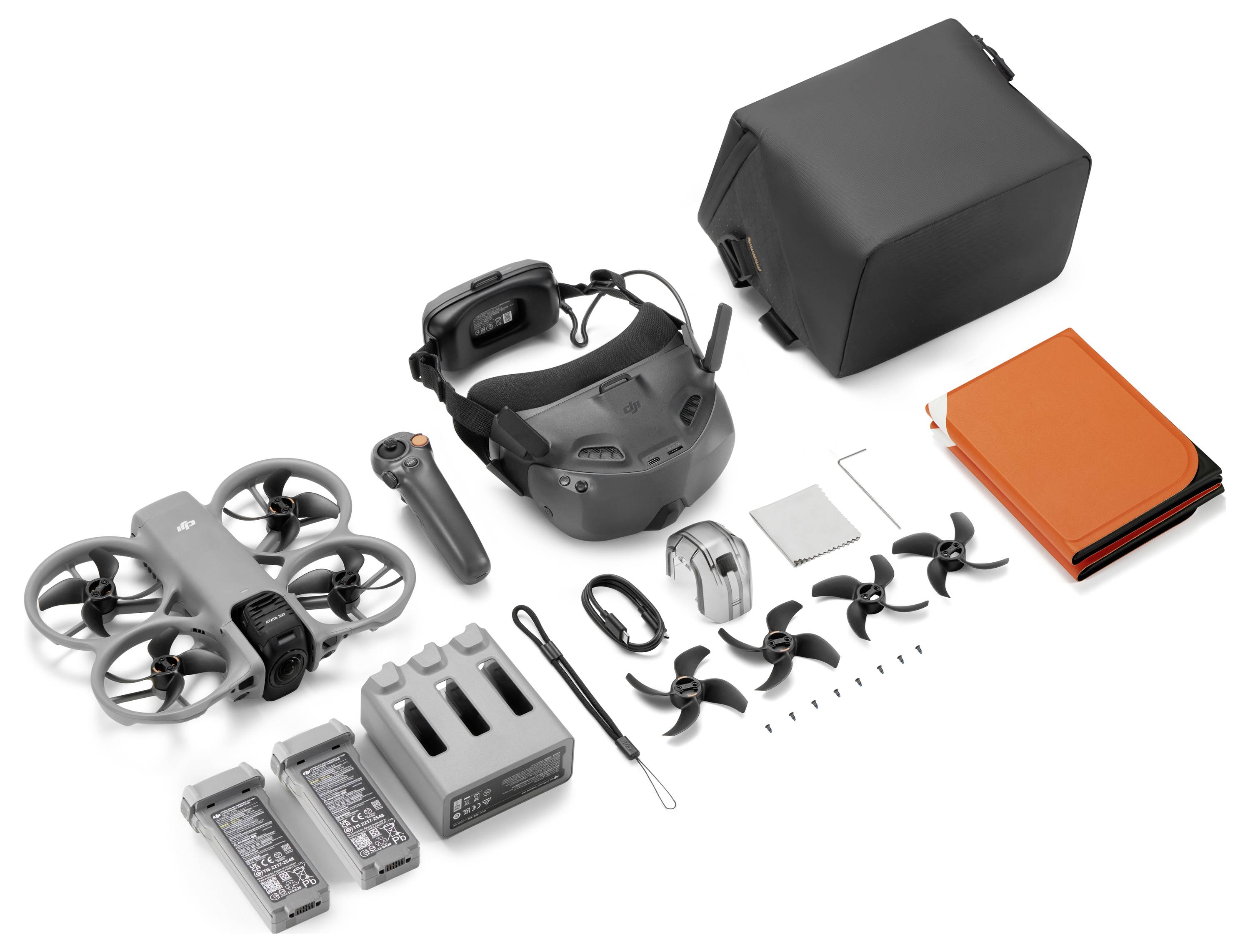 FPV-Drohnen-Kit-Komponenten auf weißem Hintergrund angeordnet, einschließlich einer kleinen Quadcopter, Brille, Controller, Batterien, Ladegerät, Antennen, Propeller, Werkzeuge und Transporttaschen.