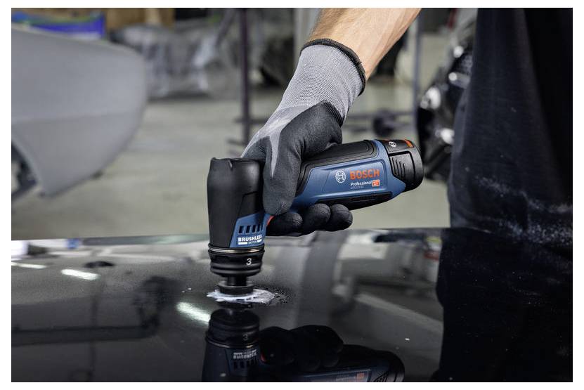 Handschuh tragend, eine Hand benutzt ein Bosch-Akku-Poliergerät auf einer schwarzen lackierten Oberfläche eines Autos.