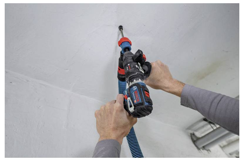 Person benutzt einen Bosch-Elektroschrauber mit einem blauen Staubsauger-Schlauch-Aufsatz zum Bohren in eine Decke.