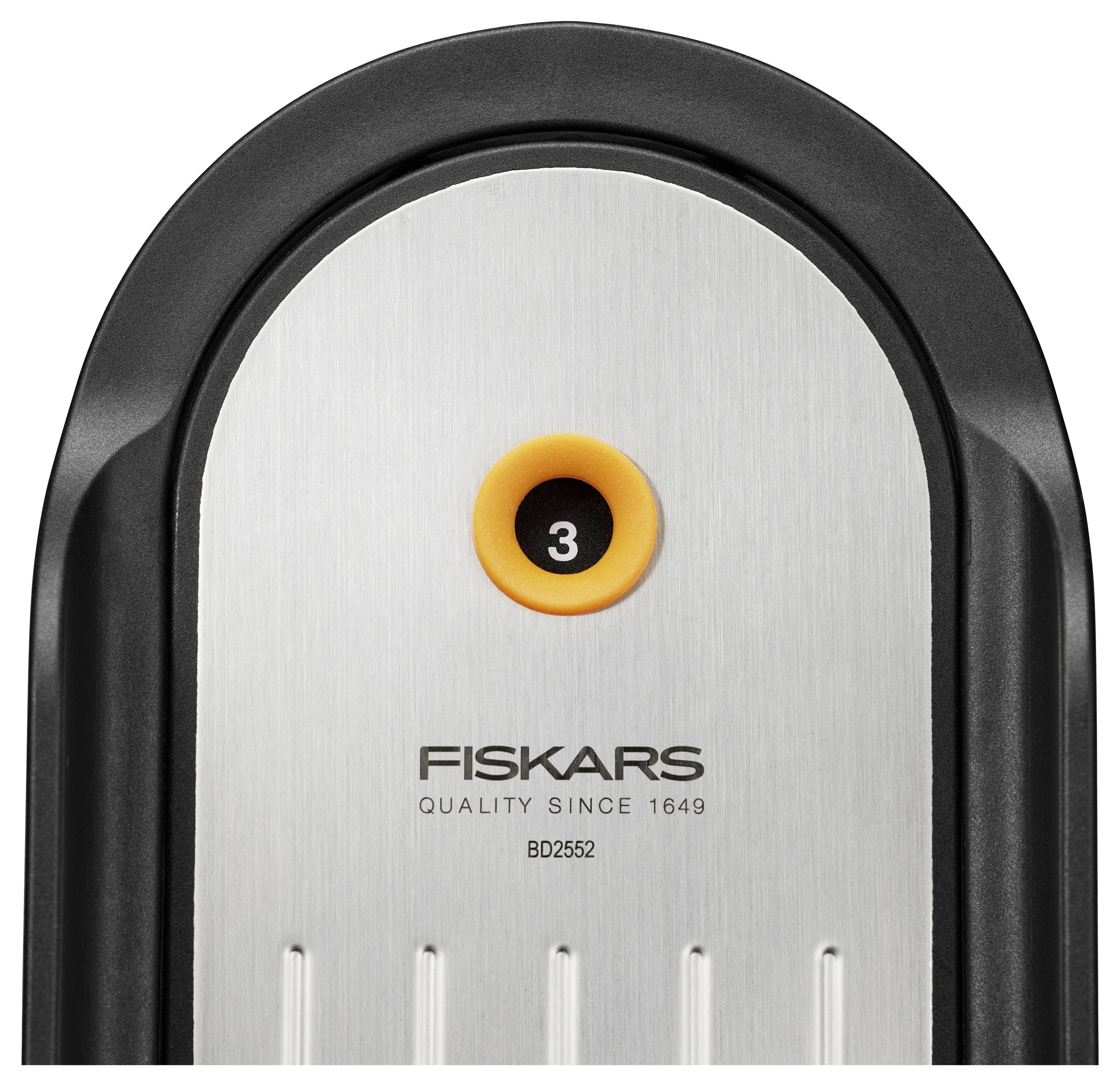 Nahaufnahme eines Fiskars-Küchengeräts mit Edelstahlklinge und schwarzem Griff; orangefarbiges kreisförmiges Detail mit der Markierung „3" oben.
