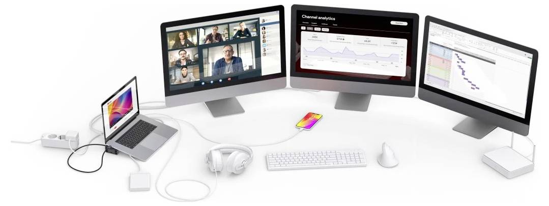 Mehrere Computermonitore zeigen eine Videokonferenz und Analyse-Dashboards an, verbunden mit einem Laptop mit Kopfhörer, Tastatur, Maus und Zubehör auf einem Schreibtisch.
