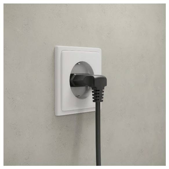 Ein schwarzer Stromstecker, der in eine weiße Wandsteckdose an einer schlichten grauen Wand gesteckt ist.