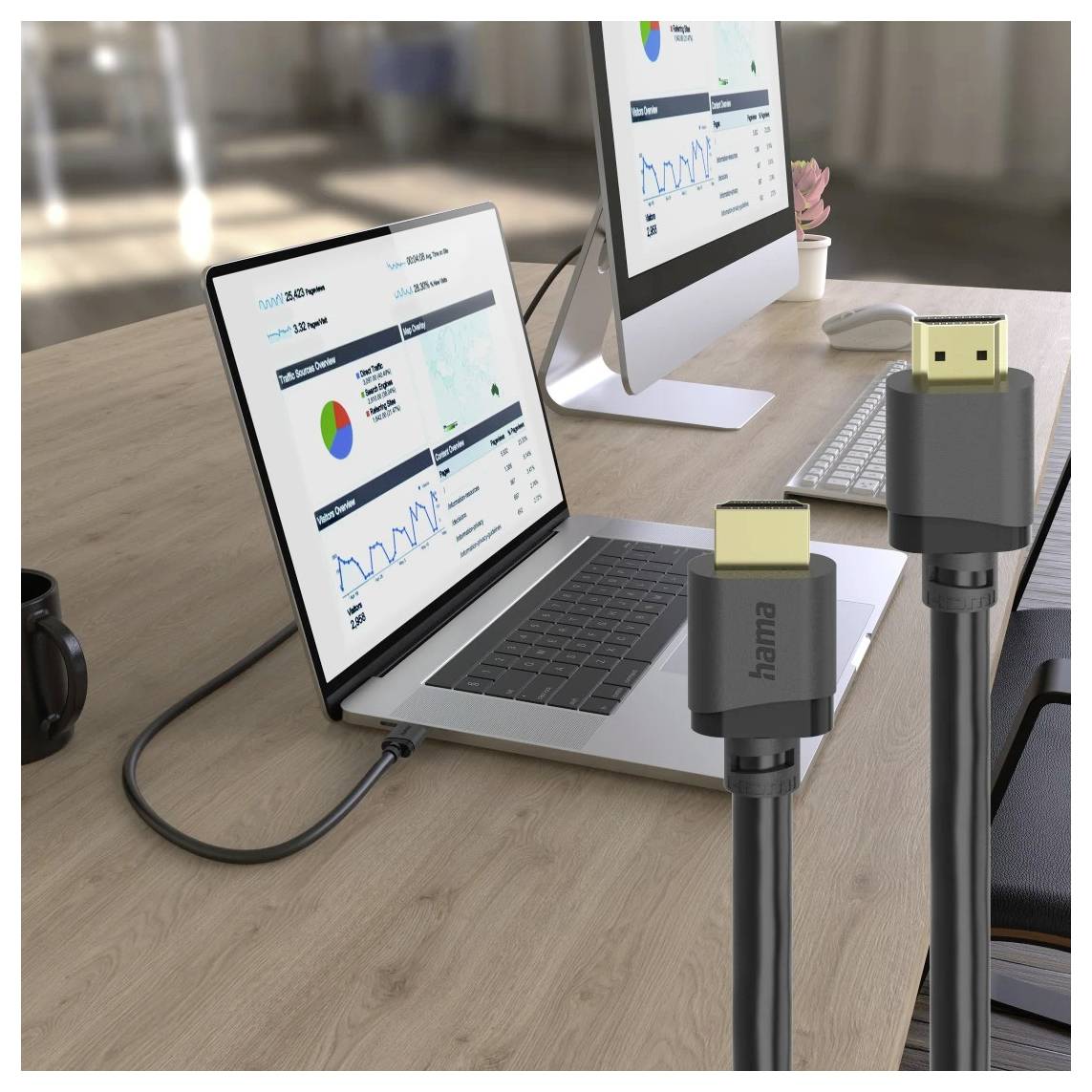 Zwei USB-C-Kabel im Vordergrund verbinden einen Laptop und einen Desktop-Monitor, die Analytics-Dashboards auf einem Schreibtisch anzeigen.