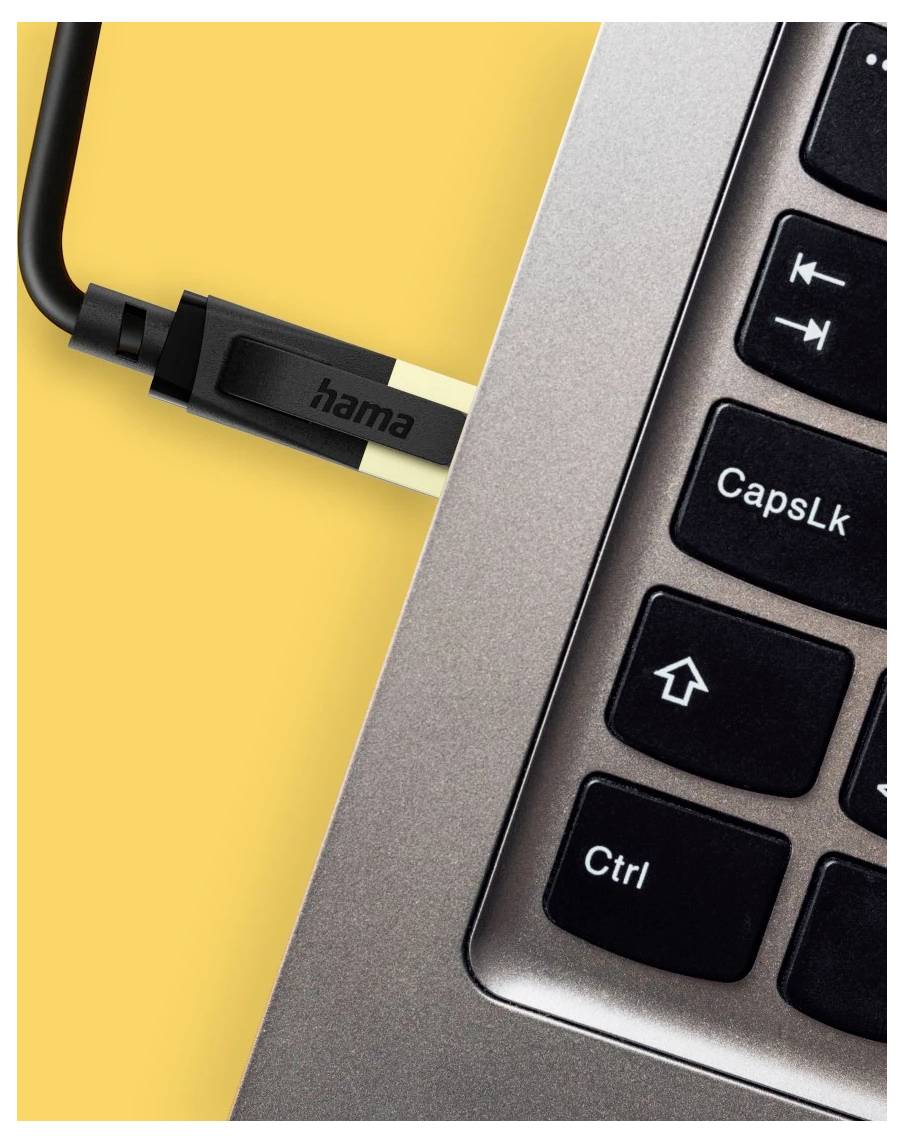 Nahaufnahme eines in einen Laptop neben der Tastatur eingesteckten USB-Kabels, das den 'hama'-Anschluss und Tasten wie CapsLk und Strg zeigt.