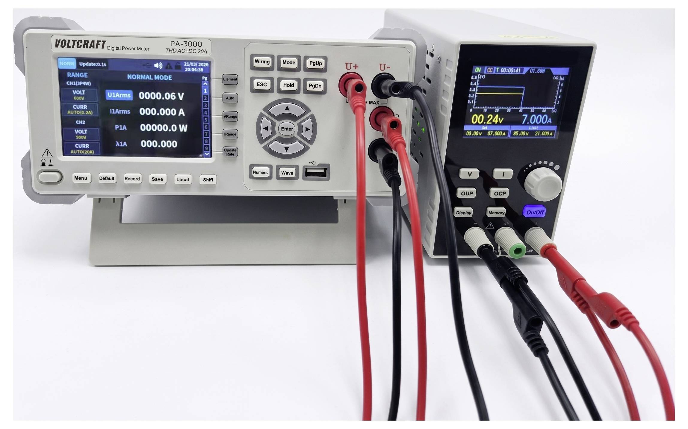 Zwei digitale Stromversorgungsgeräte für die Arbeitsfläche mit Displays und angeschlossenen roten, schwarzen und grünen Prüfleitungen, die für elektrische Tests eingerichtet sind.