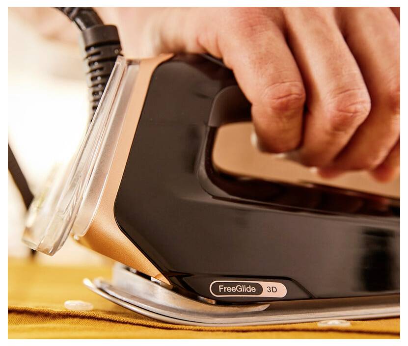 Nahaufnahme einer Hand, die ein Dampfbügeleisen mit der Aufschrift „FreeGlide 3D