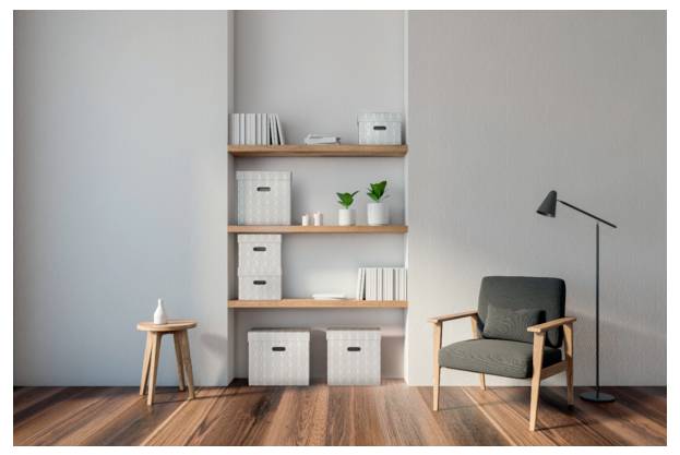 Minimalistisches modernes Wohnzimmer mit einem dunkelgrauen Sessel, einer Stehleuchte, hölzernen Regalen mit Aufbewahrungsboxen und kleinen Pflanzen sowie einem kleinen Hocker auf einem Holzboden.