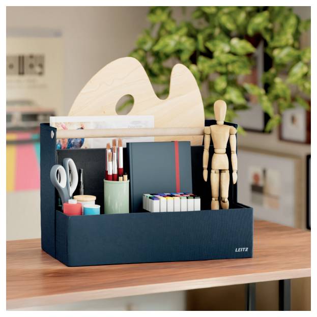 Desktop-Organizer mit Kunstbedarf, Schere, Stiften, Markern und einer hölzernen Gliederpuppe auf einem Tisch mit einer Palette im Hintergrund.