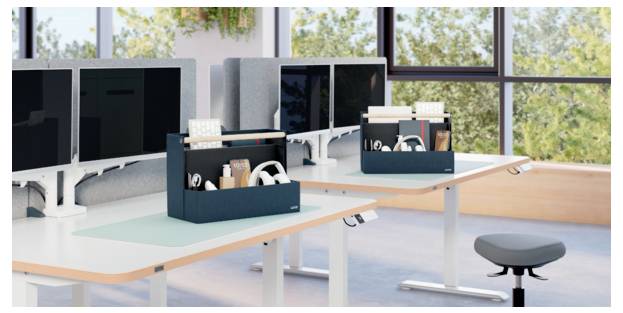 Minimalistisches Wohnzimmer mit dunklem Sessel, Stehleuchte, kleinem Hocker und Wandregalen mit Büchern, Kartons und Pflanzen.